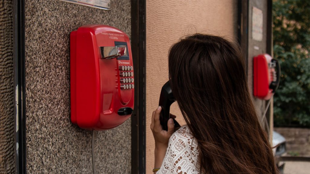 Woman using red telephone